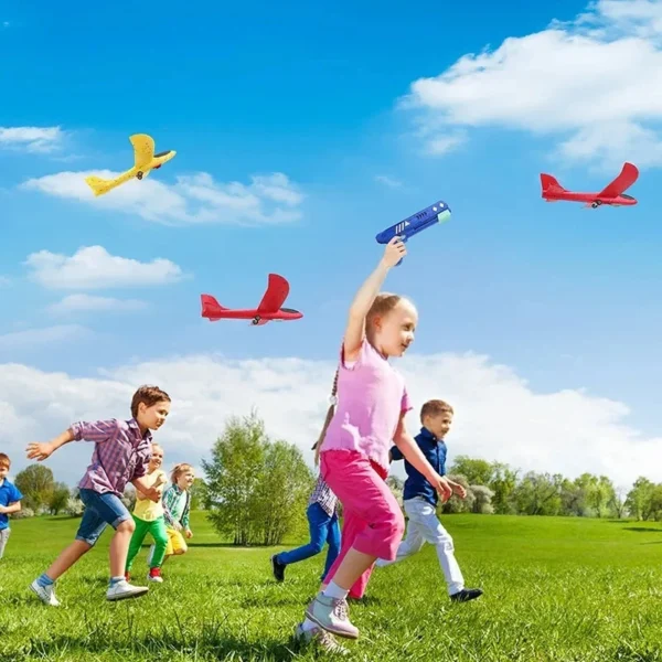 Child launching a foam airplane with a handheld catapult gun outdoors, showcasing long-range flight.